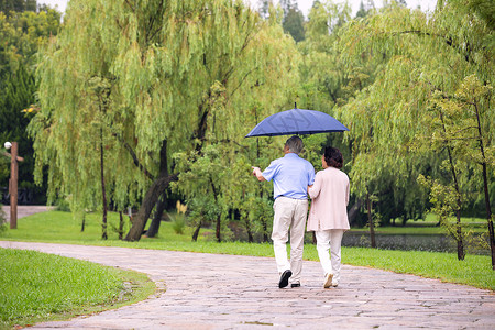 老年夫妇雨中散步背影图片素材