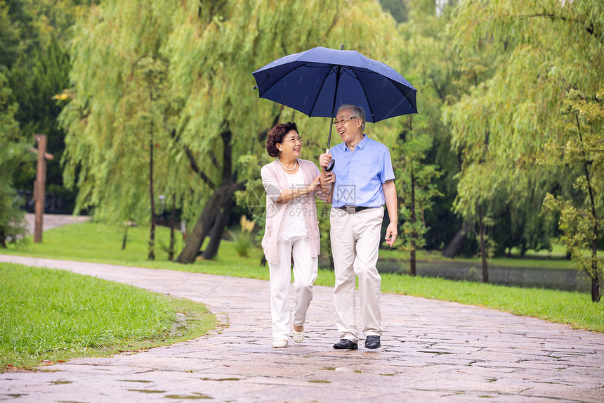 老年夫妇在公园雨中散步图片