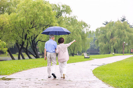 老年夫妇雨中散步背影图片素材