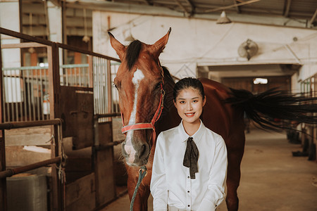 青年女性马厩牵马背景图片