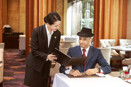 酒店服务餐厅服务员给外国客人菜单酒店管理高清图片素材