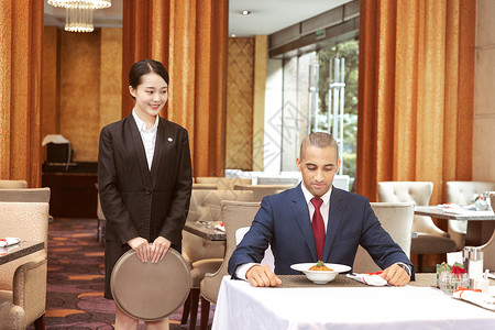 酒店服务餐厅服务员给外国客人上菜背景图片