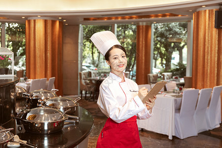 酒店服务餐厅厨师拿着记事板记录背景图片