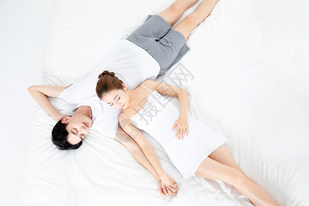年轻情侣躺在床上睡觉高清图片
