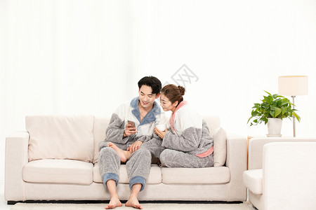 冬季青年夫妻家庭生活玩手机图片