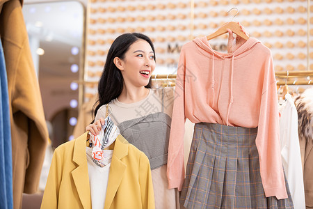 中国时尚年轻美女逛街购物挑选衣服背景