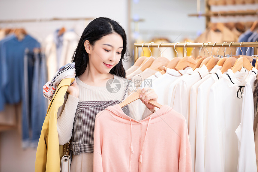 年轻美女商场购物挑选衣服