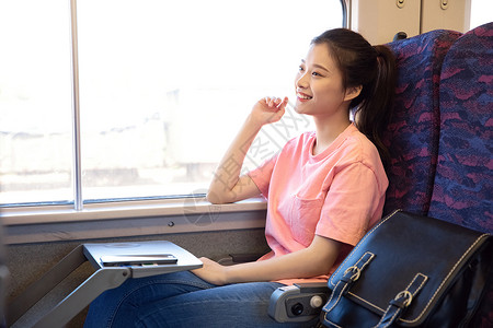 青年女性坐在高铁上黄种人高清图片素材