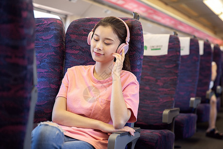 青年女性坐在高铁上听音乐高清图片素材