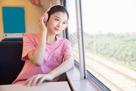青年女性坐在高铁上出行高清图片素材