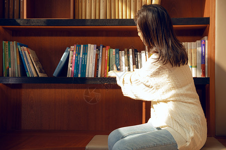 在图书馆找书的女大学生背景图片