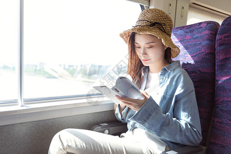 青年女性在座位上看书车厢高清图片素材