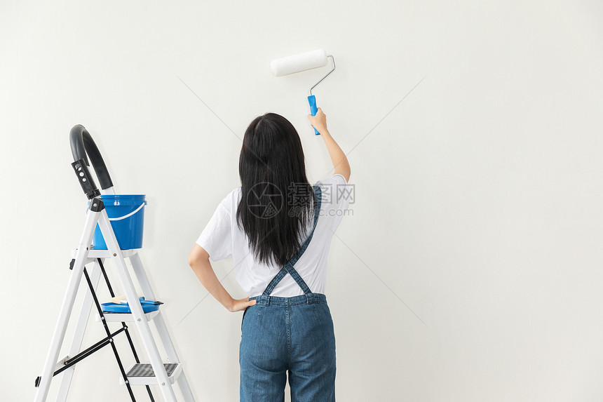 青年女性装修刷墙背影图片