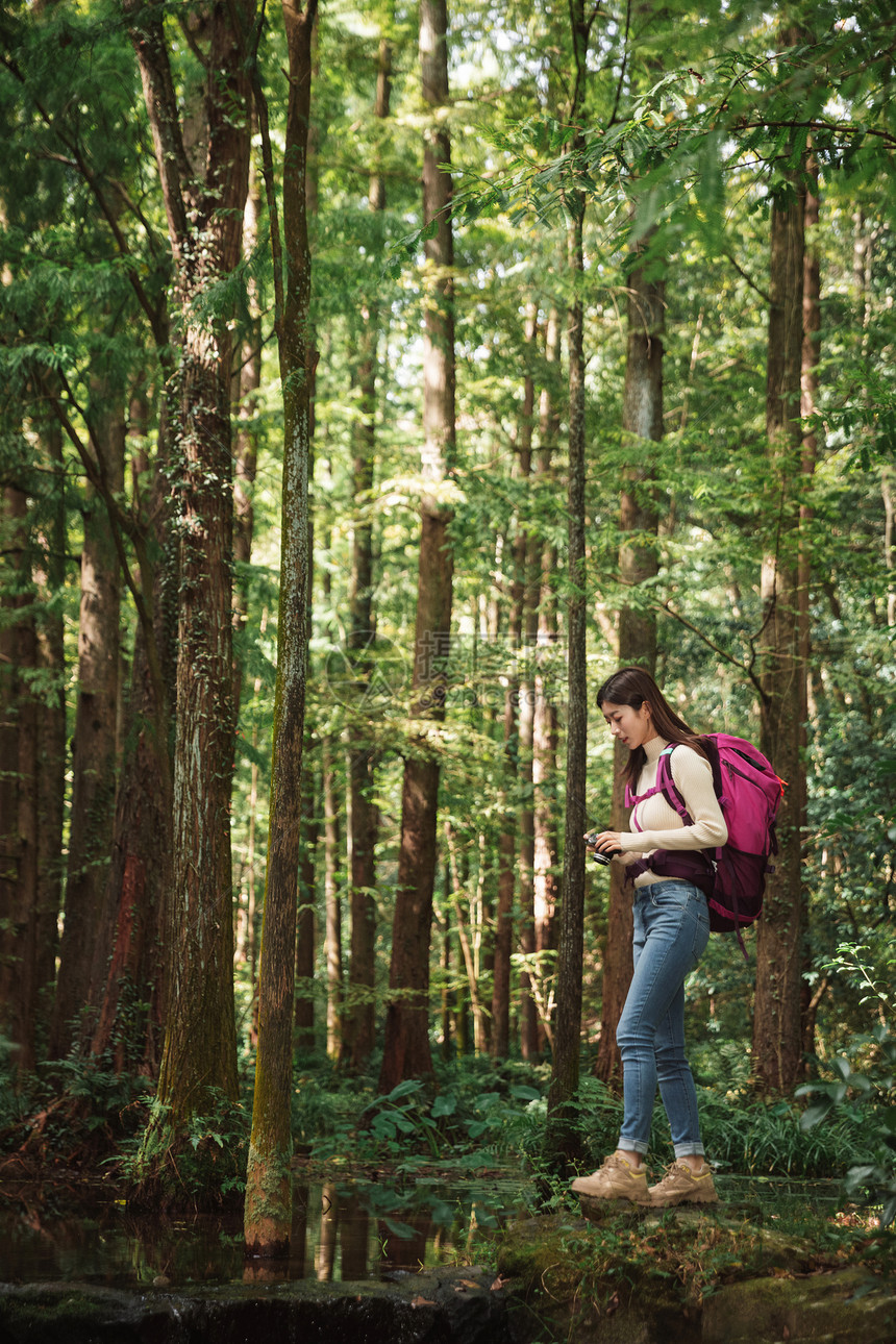 青年女性在森林里拍照图片