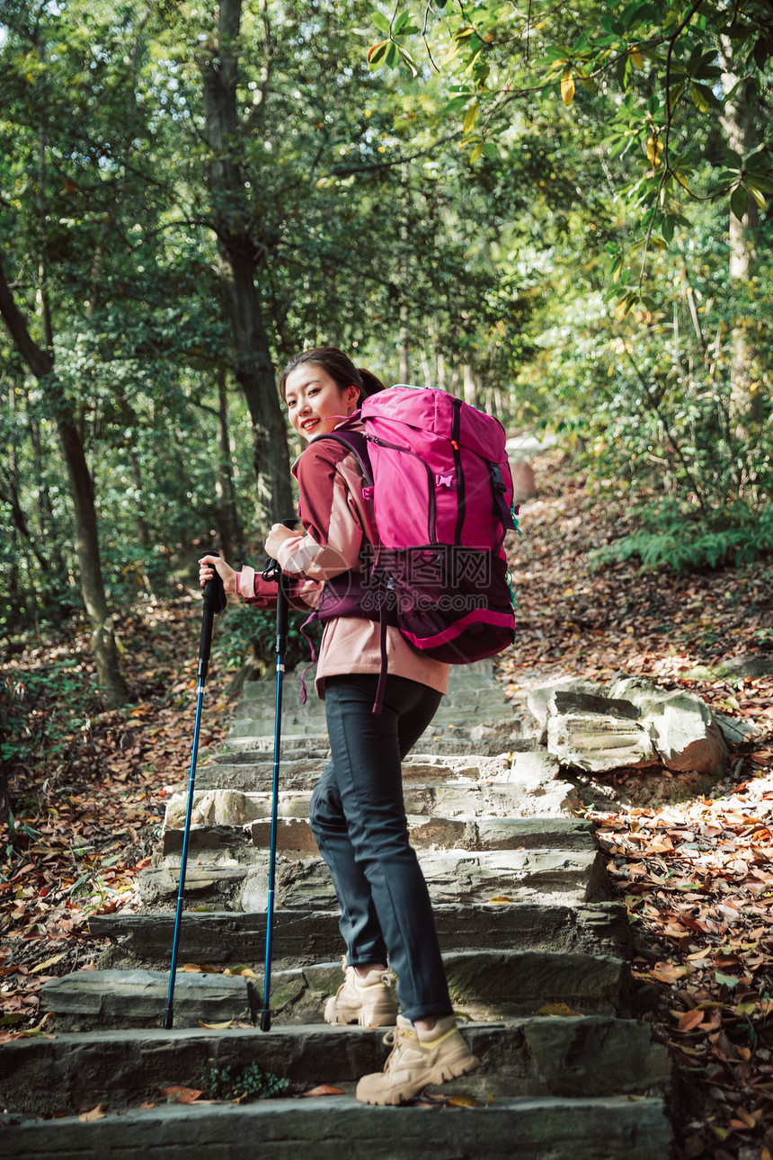 用登山杖爬山的女性形象图片