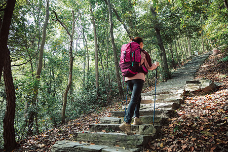 用登山杖爬山的女性形象背景图片