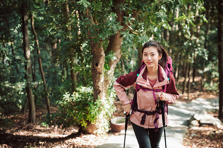 用登山杖爬山的女性形象图片