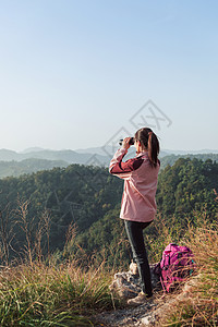 手拿望远镜望眼镜看风景的女生背景