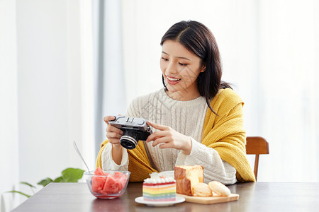 居家美女拿相机拍照背景图片