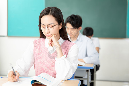 学生做笔记青年男女认真复习考研背景