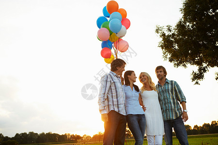 两对夫妇在日落时拿着气球图片