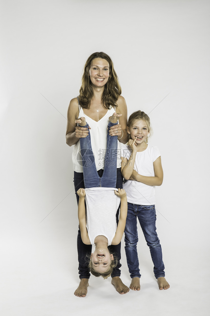 画室中两个女儿中的一个倒立着的中年妇女的肖像图片