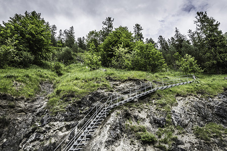 陡峭岩石山坡上楼梯的低角度视图图片