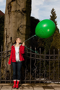 拿着绿色气球的女人图片