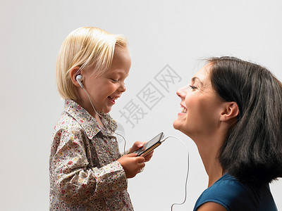 听MP3女儿和母亲在听音乐背景