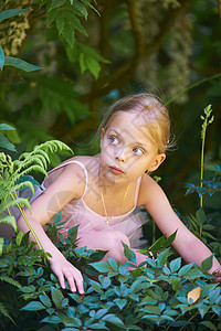 穿芭蕾服装的女孩躲在灌木丛里图片