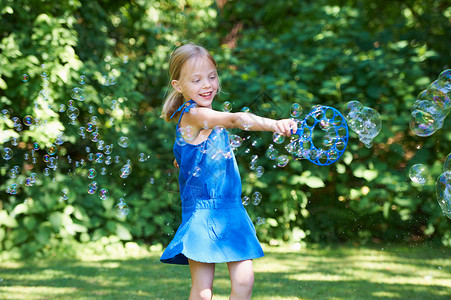 在后院玩泡泡的女孩高清图片