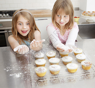 两个用面粉做蛋糕的女孩高清图片