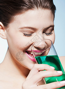 微笑的女人喝着一杯水图片