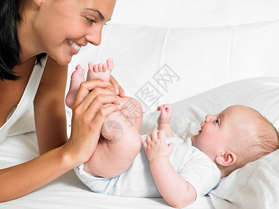 母亲亲吻新生儿的脚背景图片