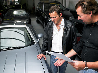 两个男人在车库里讨论一桩买卖背景图片