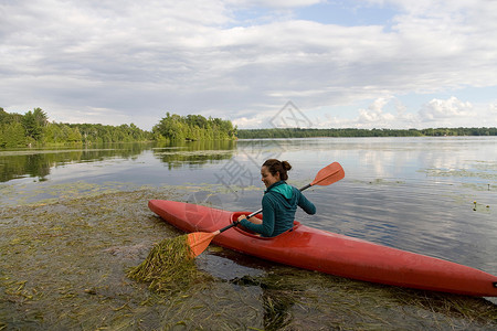 女子在湖上划独木舟图片