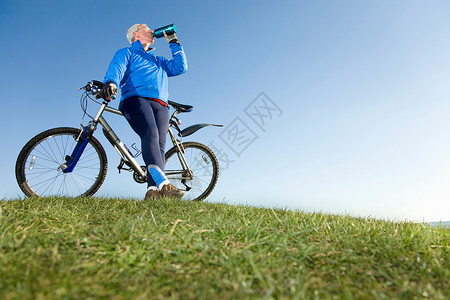 骑自行车时喝水的老人图片