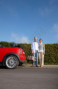 成熟夫妇站在车旁边图片