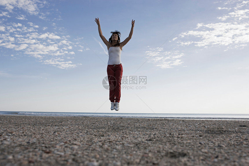 在海滩上跳跃的女人图片