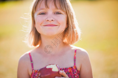 小女孩拿着苹果微笑图片