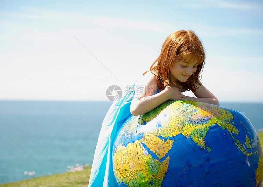小女孩看着充气的地球仪图片