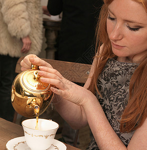 年轻女子在咖啡馆喝茶盘高清图片素材