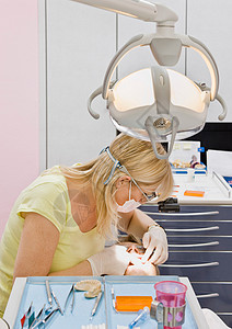 为男性患者工作的女性牙医图片