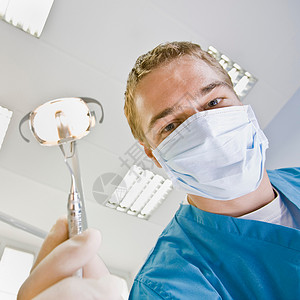 带牙科工具的男性牙医图片
