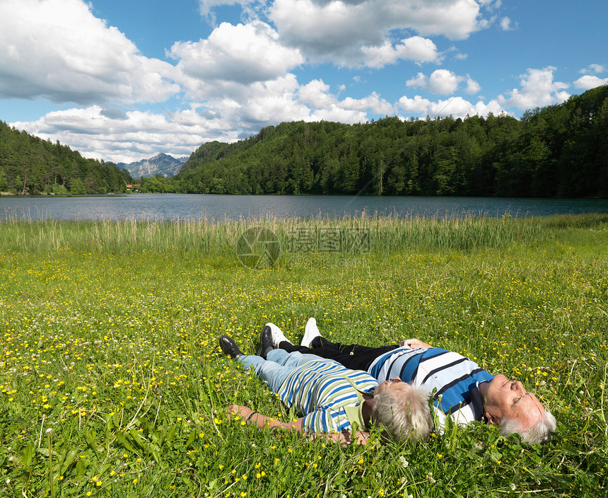 老夫妇躺在湖边的田里图片