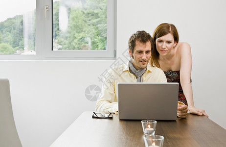 男人和女人看着笔记本电脑图片