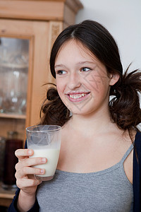 在厨房喝牛奶的微笑女孩图片