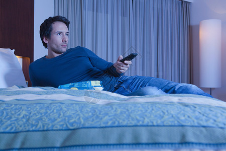 酒店床上的男人看电视背景图片