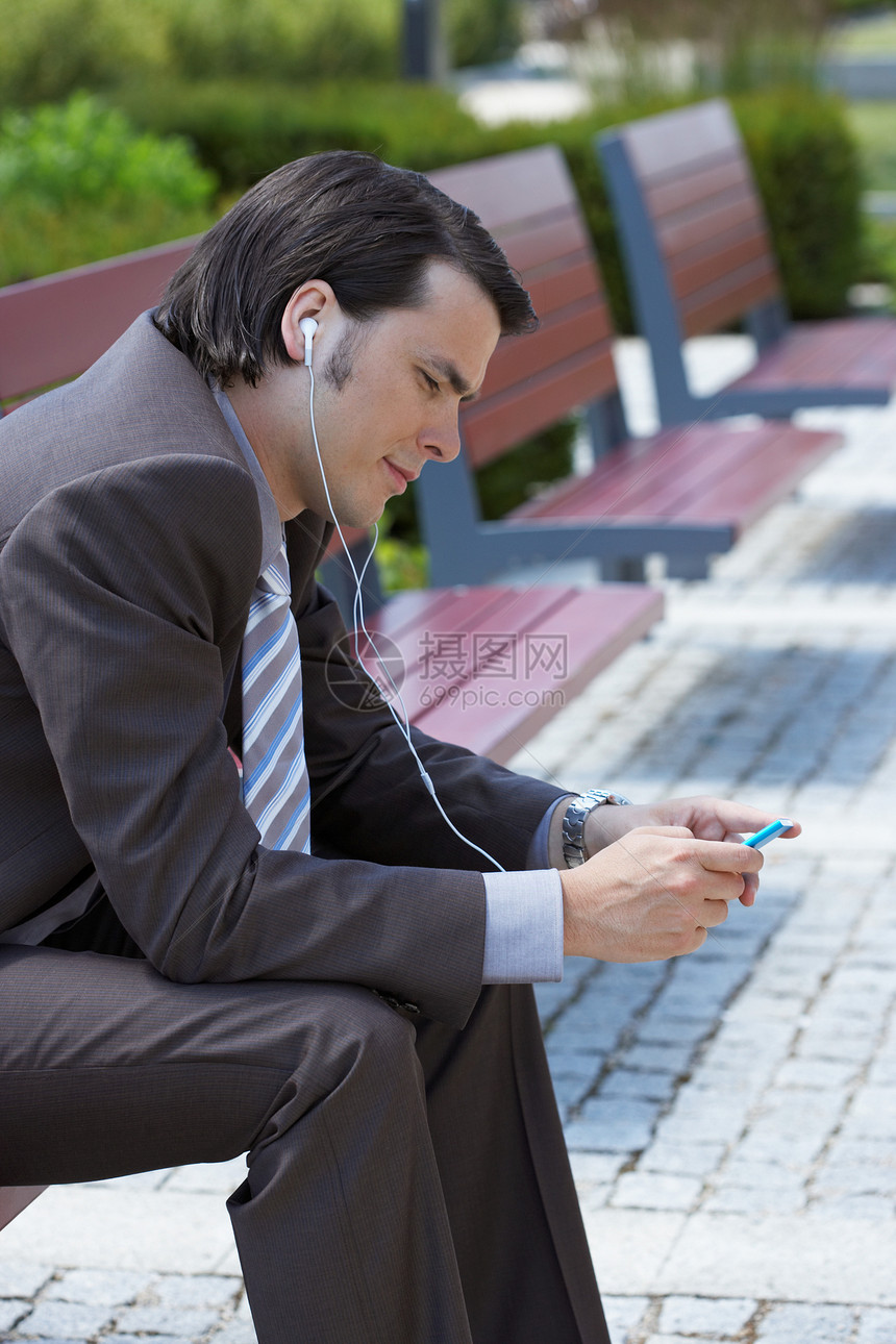 商人坐在MP3的长椅上图片