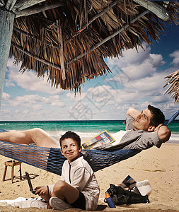 父亲和儿子在海滩上放松图片